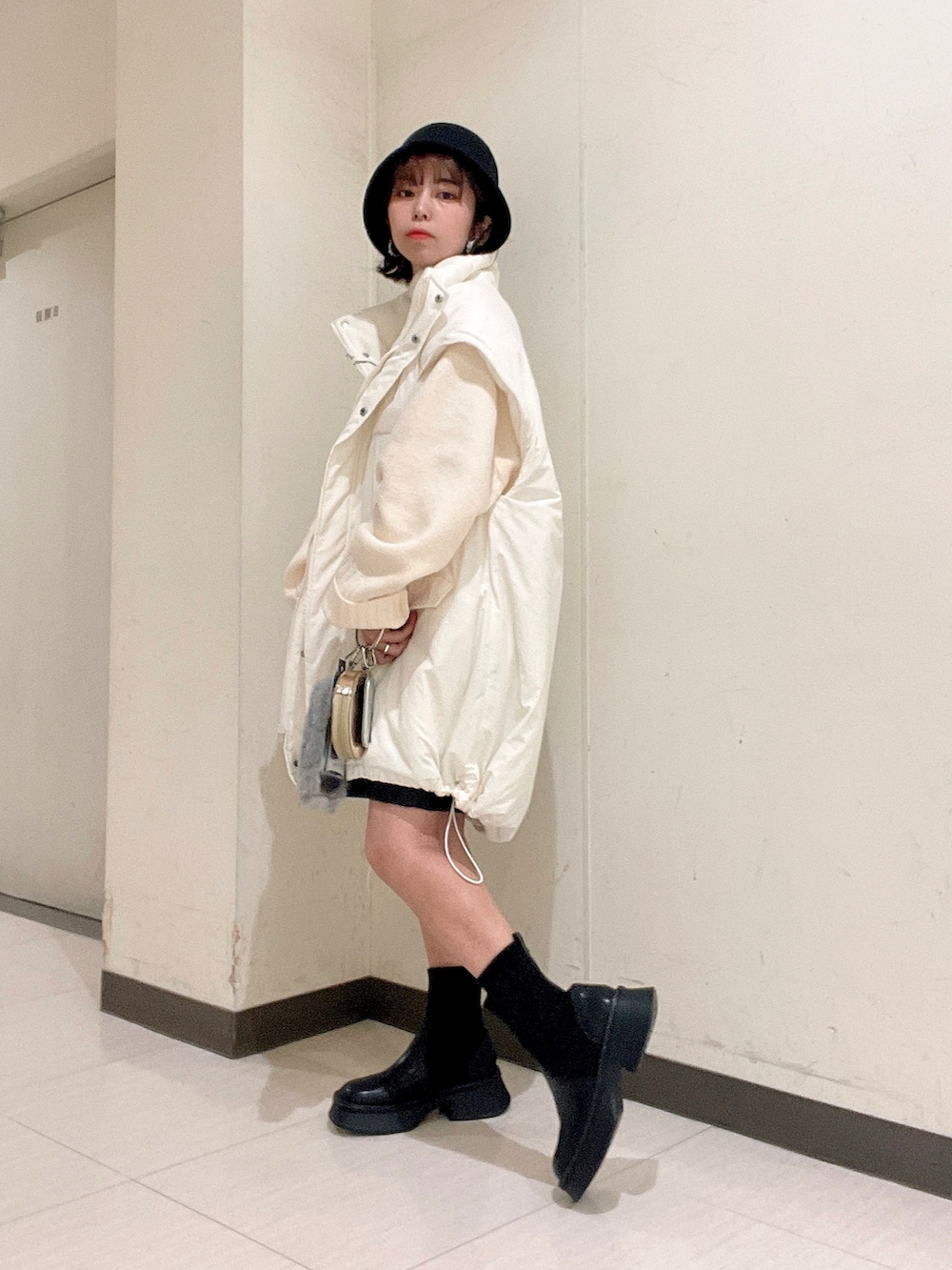 ホワイト系のニット/セーター、ブラック系のその他パンツ、ホワイト系のナイロンジャケットを着用したレディースの秋コーディネートの4枚目の写真