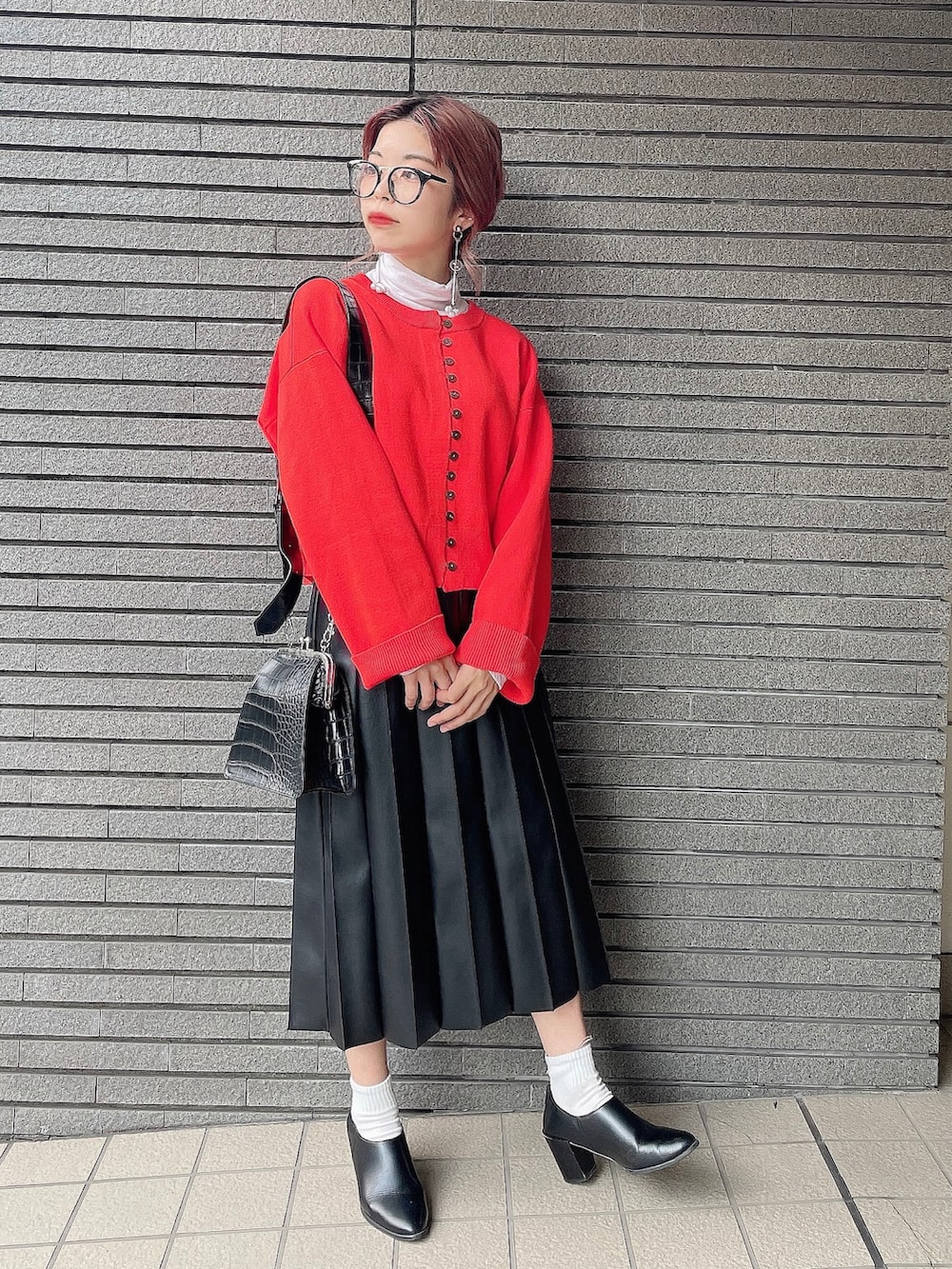 オレンジ系のカーディガン/ボレロ、ブラック系のスカート、ブラック系のパンプスを着用したレディースの秋コーディネートの4枚目の写真