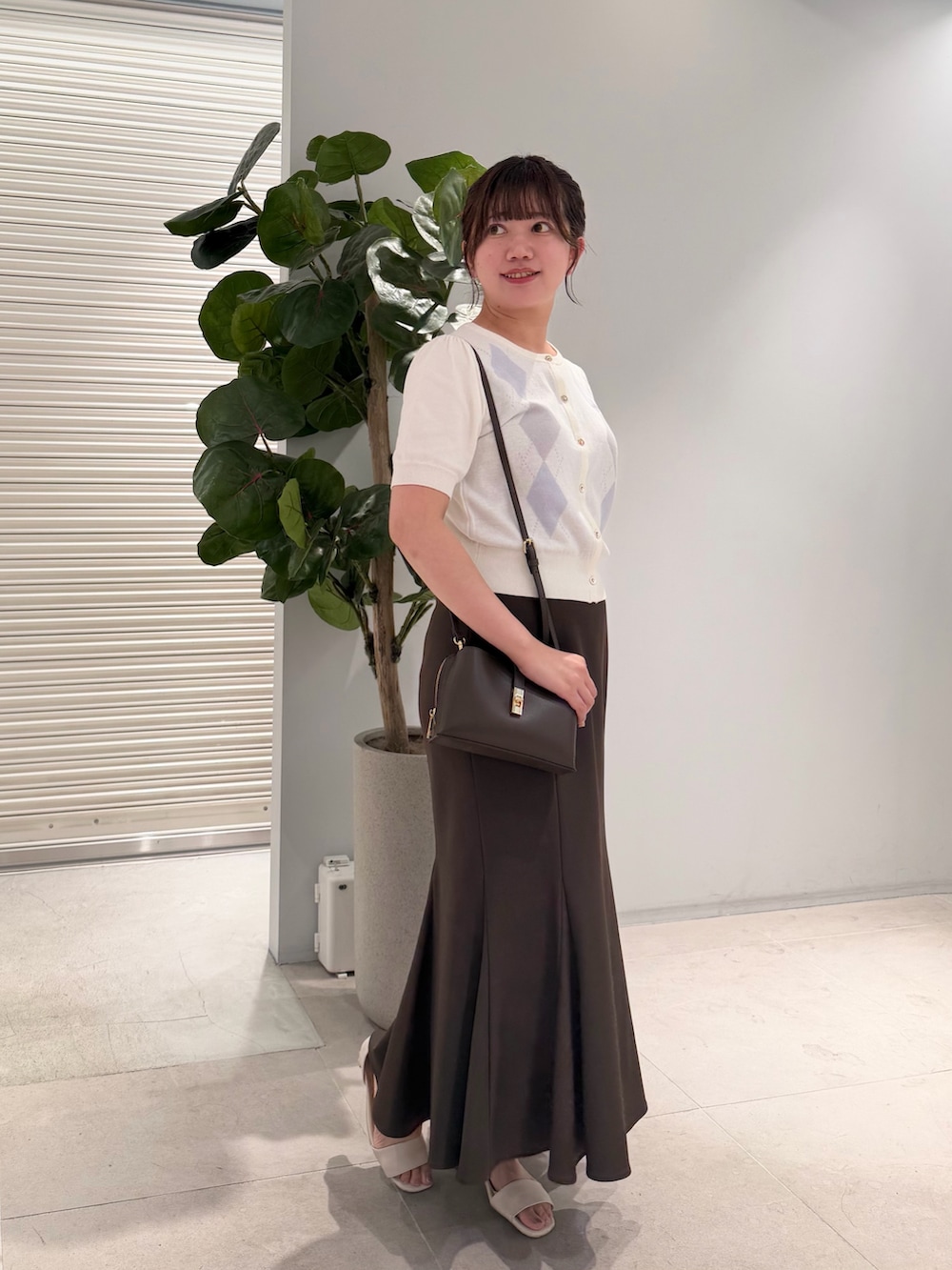 ホワイト系のカーディガン/ボレロ、ブラウン系のスカートを着用したレディースの夏コーディネートの3枚目の写真