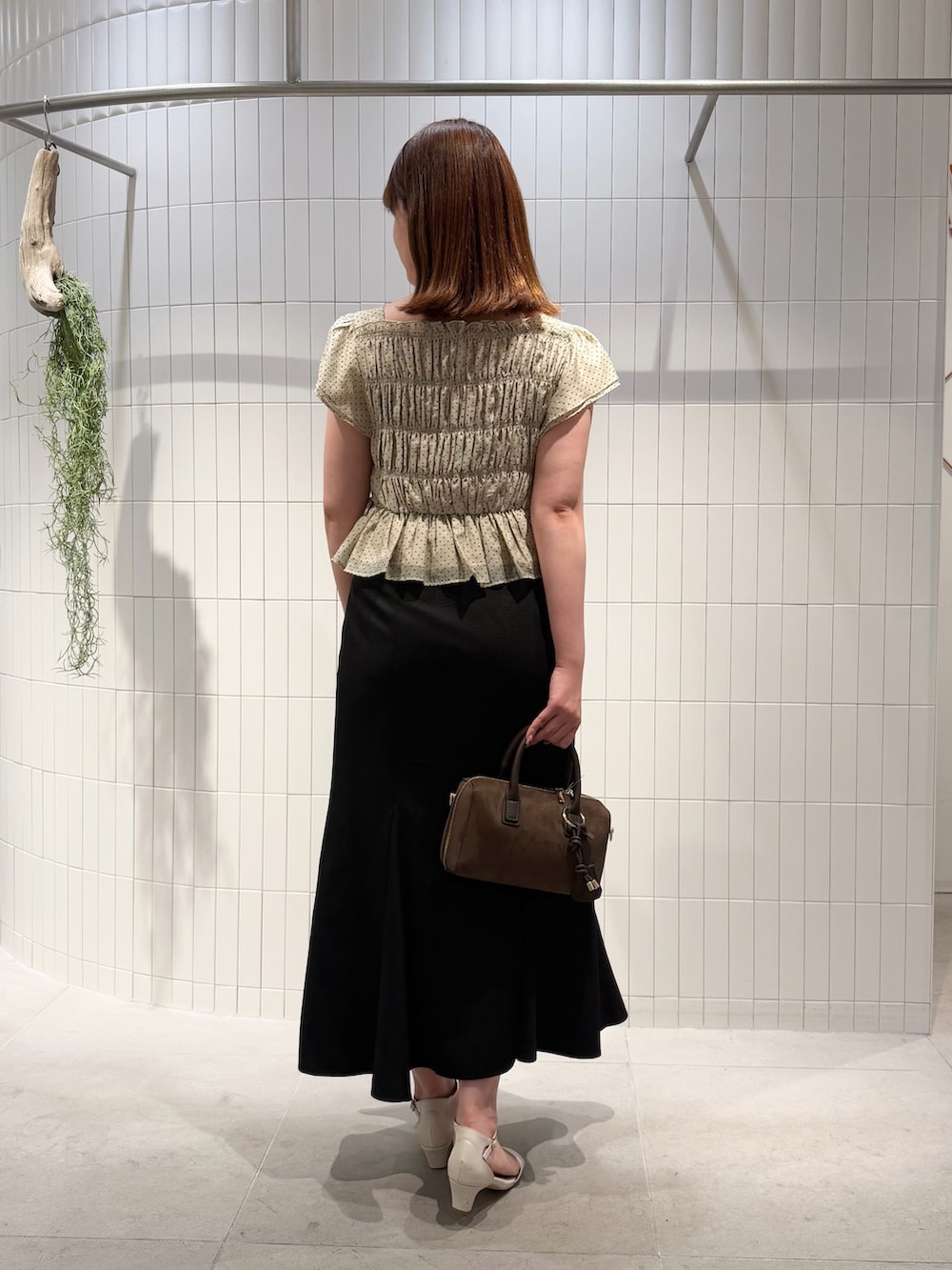 ブラック系のスカート、ベージュ系のシャツ/ブラウス、ブラウン系のボストンバッグを着用したレディースの夏コーディネートの3枚目の写真