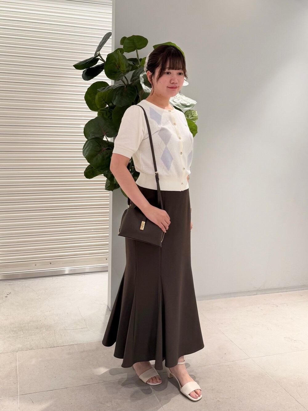 ホワイト系のカーディガン/ボレロ、ブラウン系のスカートを着用したレディースの夏コーディネートの2枚目の写真