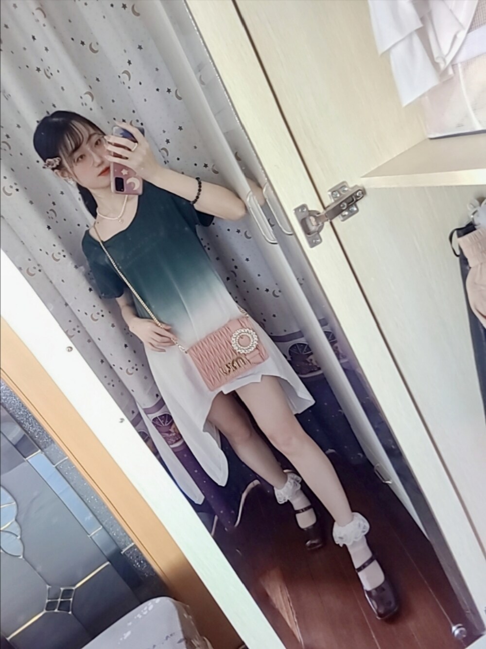 ピンク系のトートバッグ、ブラウン系のブーティ、ゴールド系のネックレスを着用したレディースの秋コーディネートの2枚目の写真