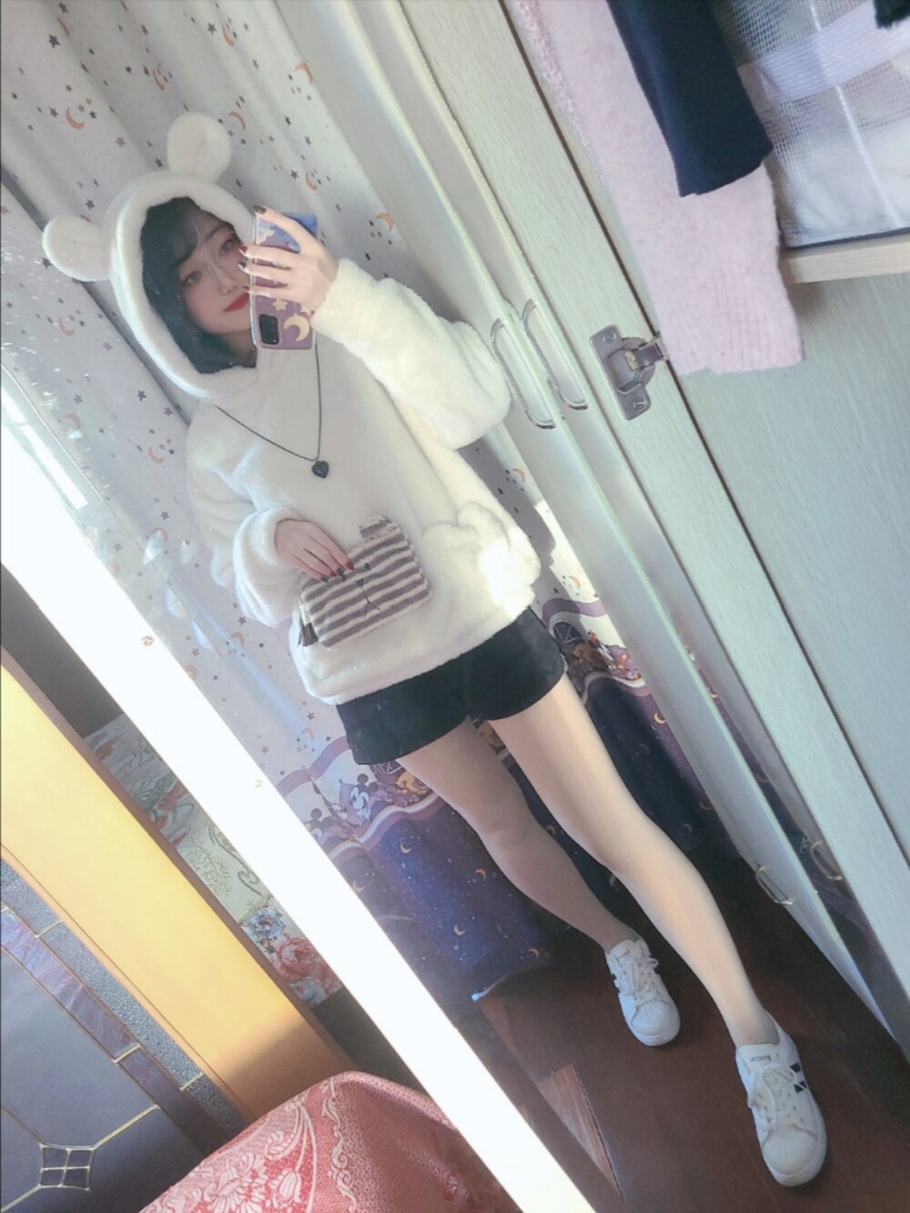 ホワイト系のスニーカー、ブラック系のカーゴパンツ、ホワイト系のパーカーを着用したレディースの秋コーディネートの2枚目の写真