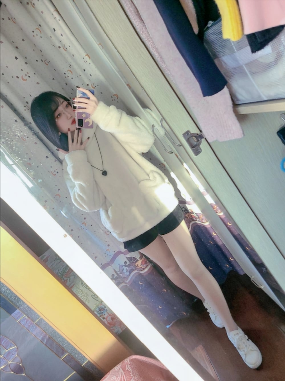 ホワイト系のパーカー、ブラック系のカーゴパンツ、ホワイト系のスニーカーを着用したレディースの冬コーディネートの3枚目の写真