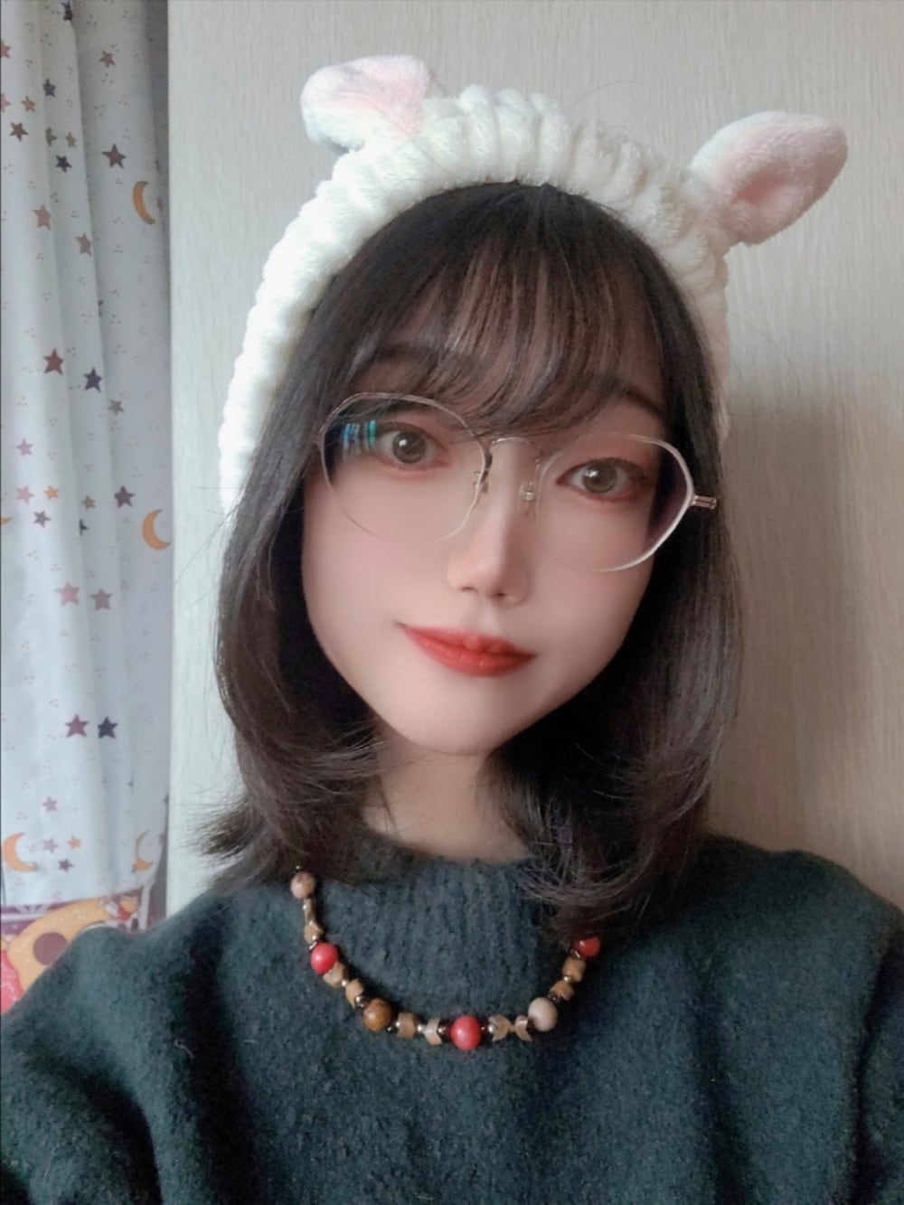 グリーン系のニット/セーター、ホワイト系のヘアバンド、シルバー系のメガネを着用したレディースの冬コーディネートの3枚目の写真