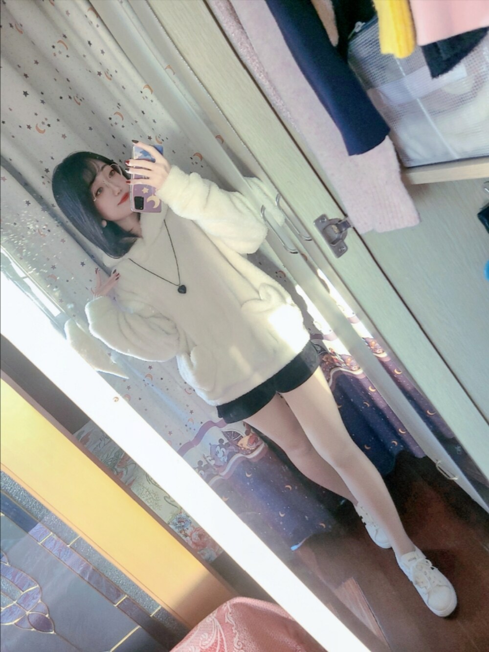 ホワイト系のパーカー、ブラック系のカーゴパンツ、ホワイト系のスニーカーを着用したレディースの冬コーディネートの4枚目の写真