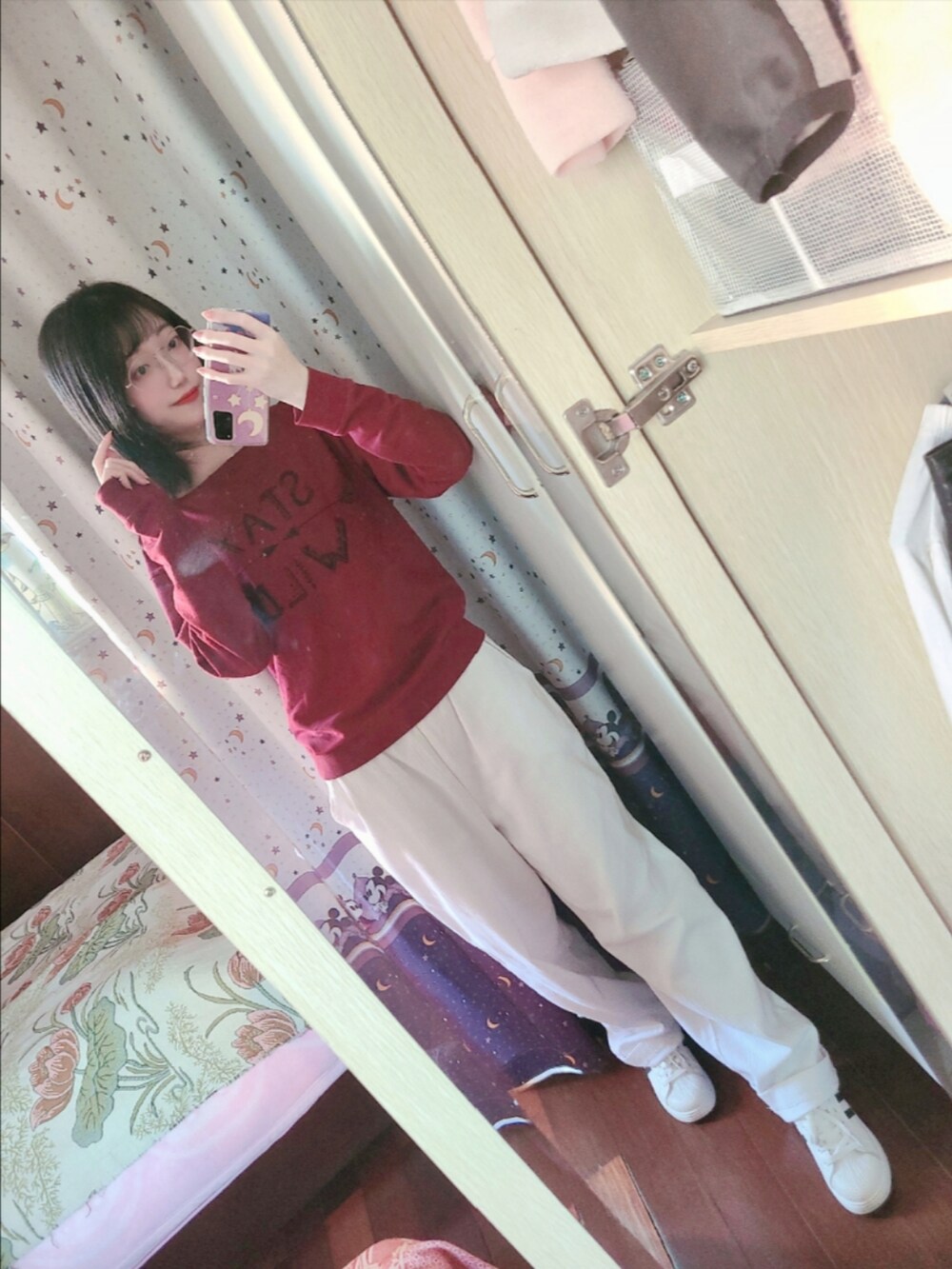 レッド系のスウェット、ホワイト系のスニーカー、ブルー系のマニキュア/ジェルネイルを着用したレディースの秋コーディネートの2枚目の写真