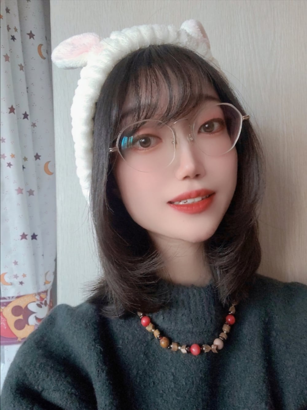 グリーン系のニット/セーター、ホワイト系のヘアバンド、シルバー系のメガネを着用したレディースの冬コーディネートの2枚目の写真