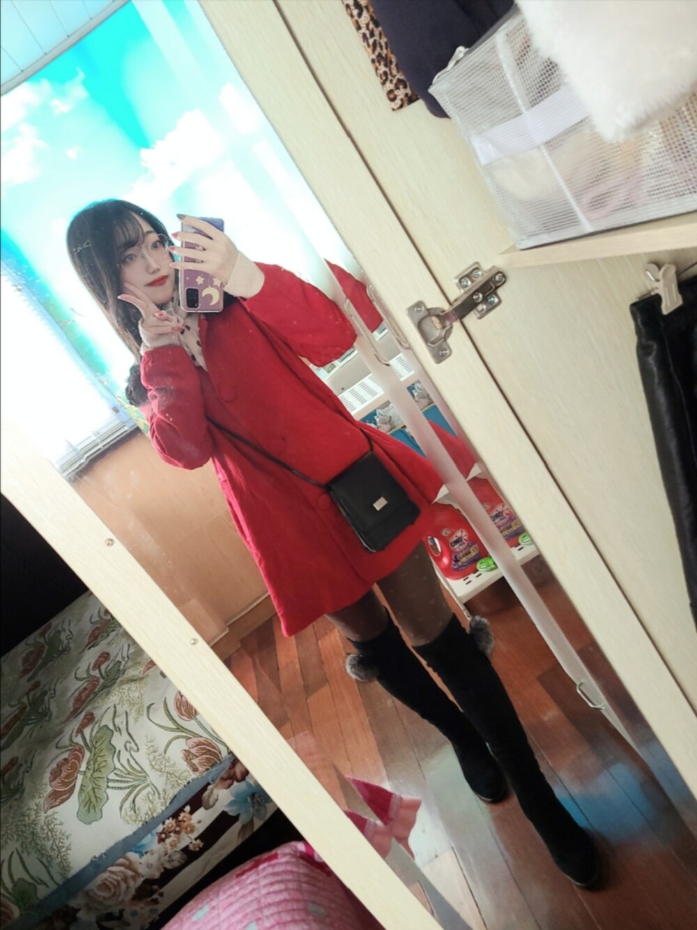 レッド系のピーコート、ブラック系のショルダーバッグ、ブラック系のブーツを着用したレディースの冬コーディネートの2枚目の写真