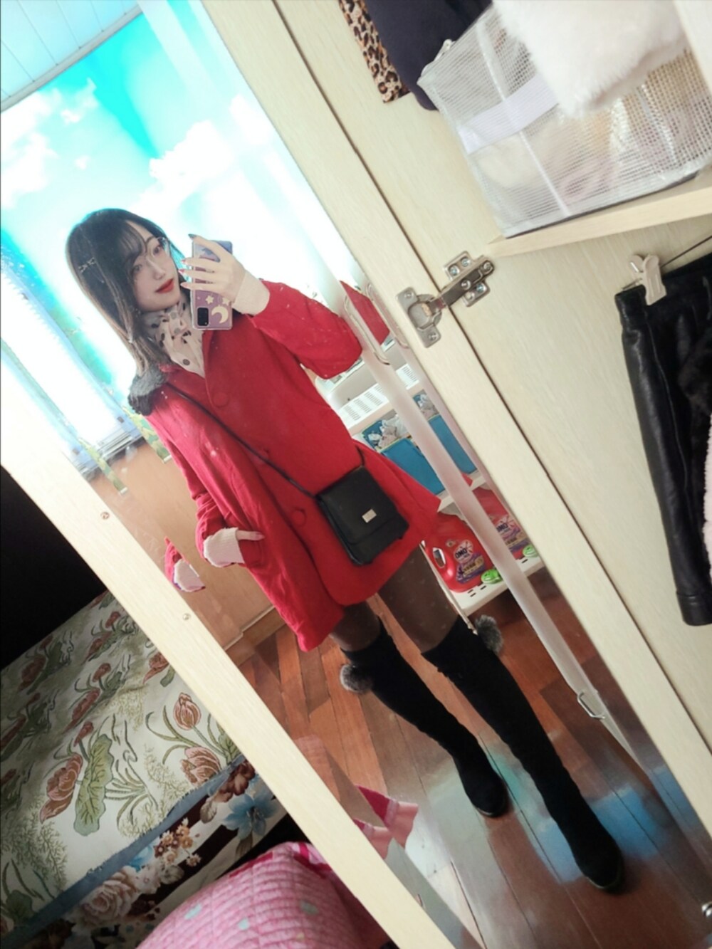 レッド系のピーコート、ブラック系のショルダーバッグ、ブラック系のブーツを着用したレディースの冬コーディネートの3枚目の写真