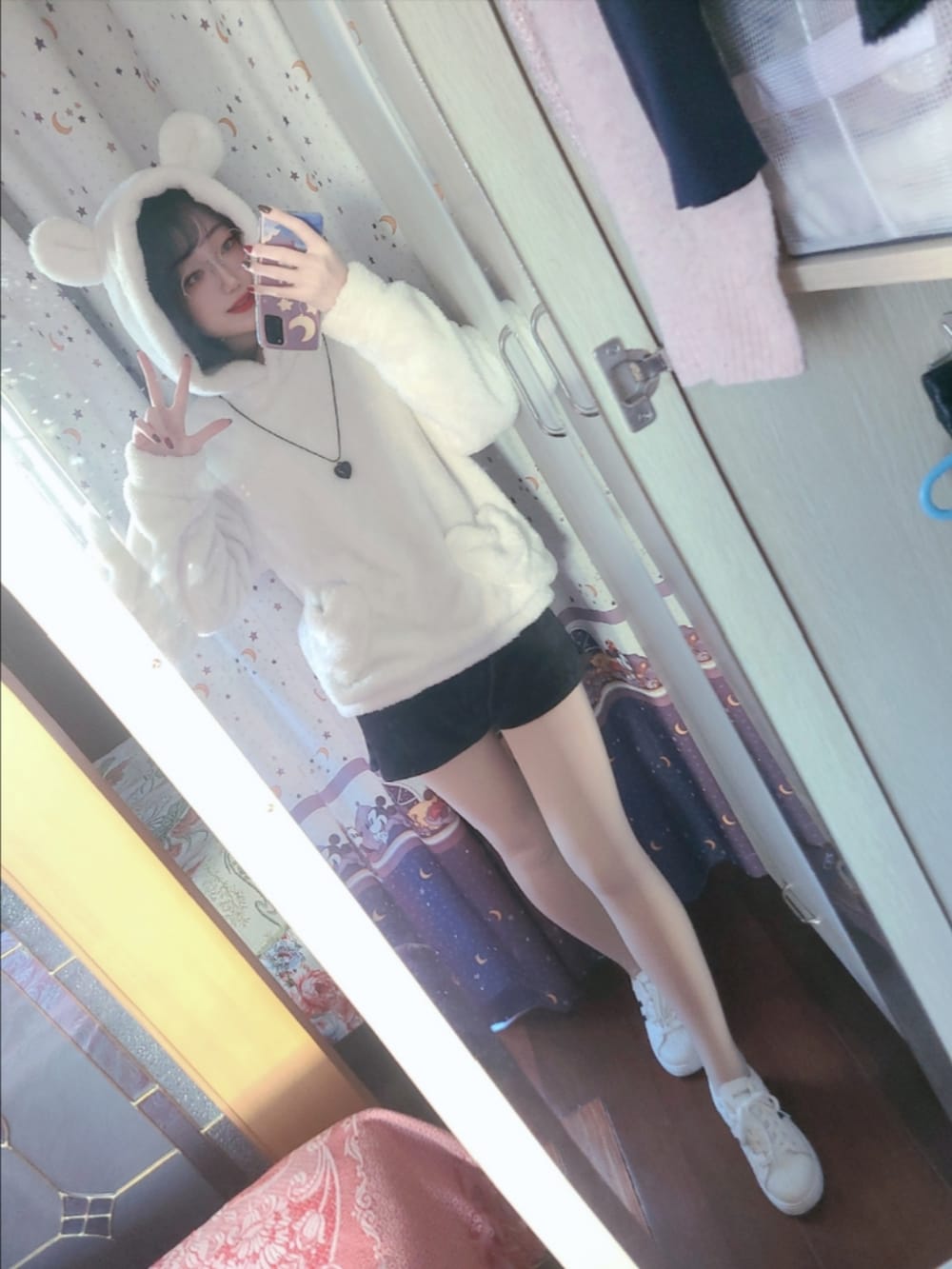 ホワイト系のスニーカー、ブラック系のカーゴパンツ、ホワイト系のパーカーを着用したレディースの秋コーディネートの4枚目の写真