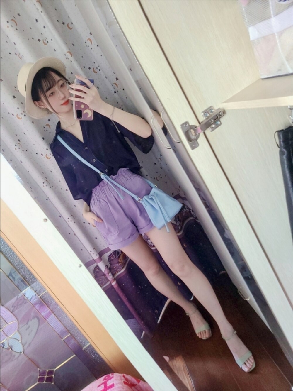 パープル系のカーゴパンツ、ブルー系のドラムバッグ、グリーン系のサンダルを着用したレディースの夏コーディネートの3枚目の写真