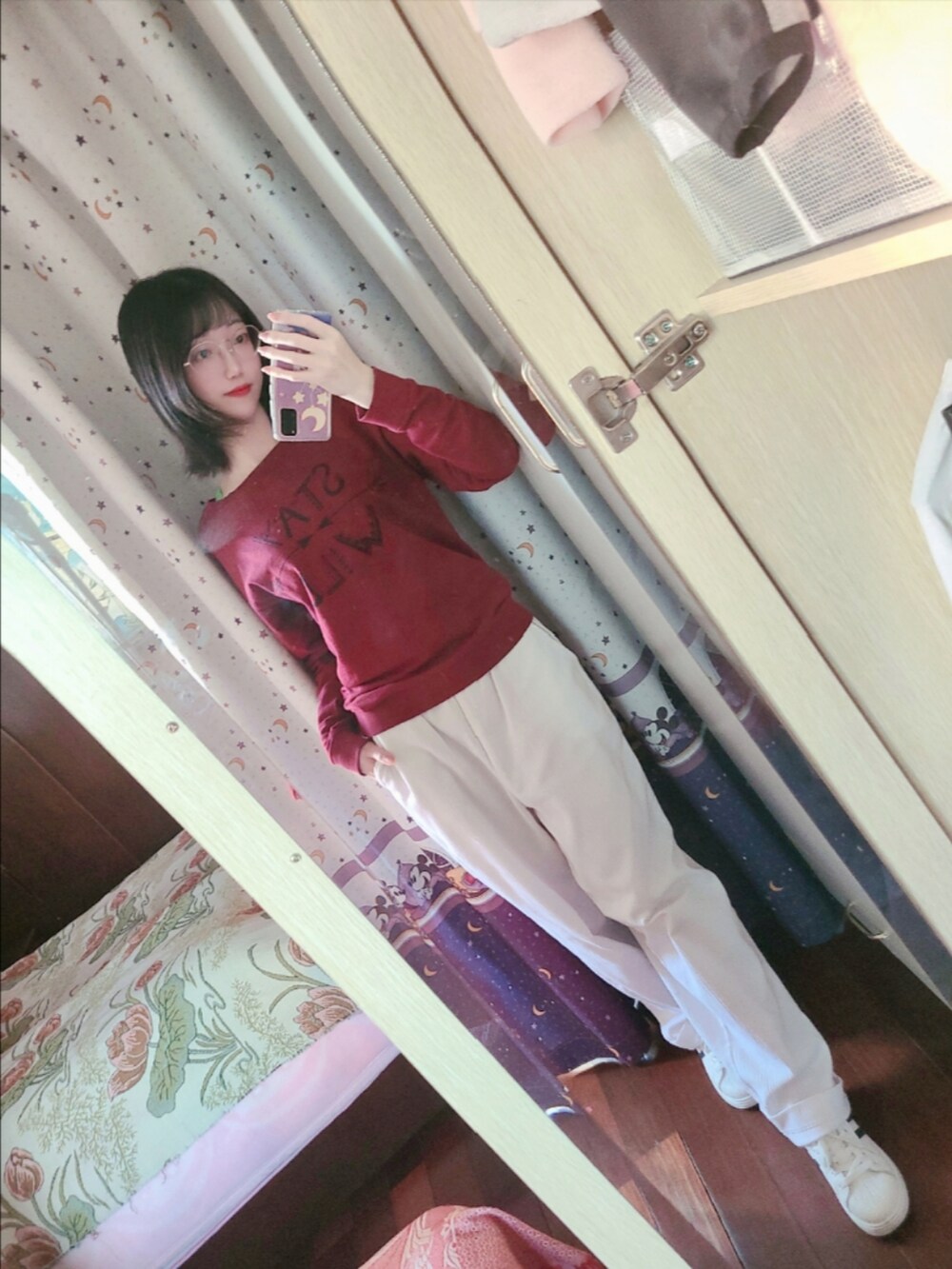 レッド系のスウェット、ホワイト系のスニーカー、ブルー系のマニキュア/ジェルネイルを着用したレディースの秋コーディネートの3枚目の写真