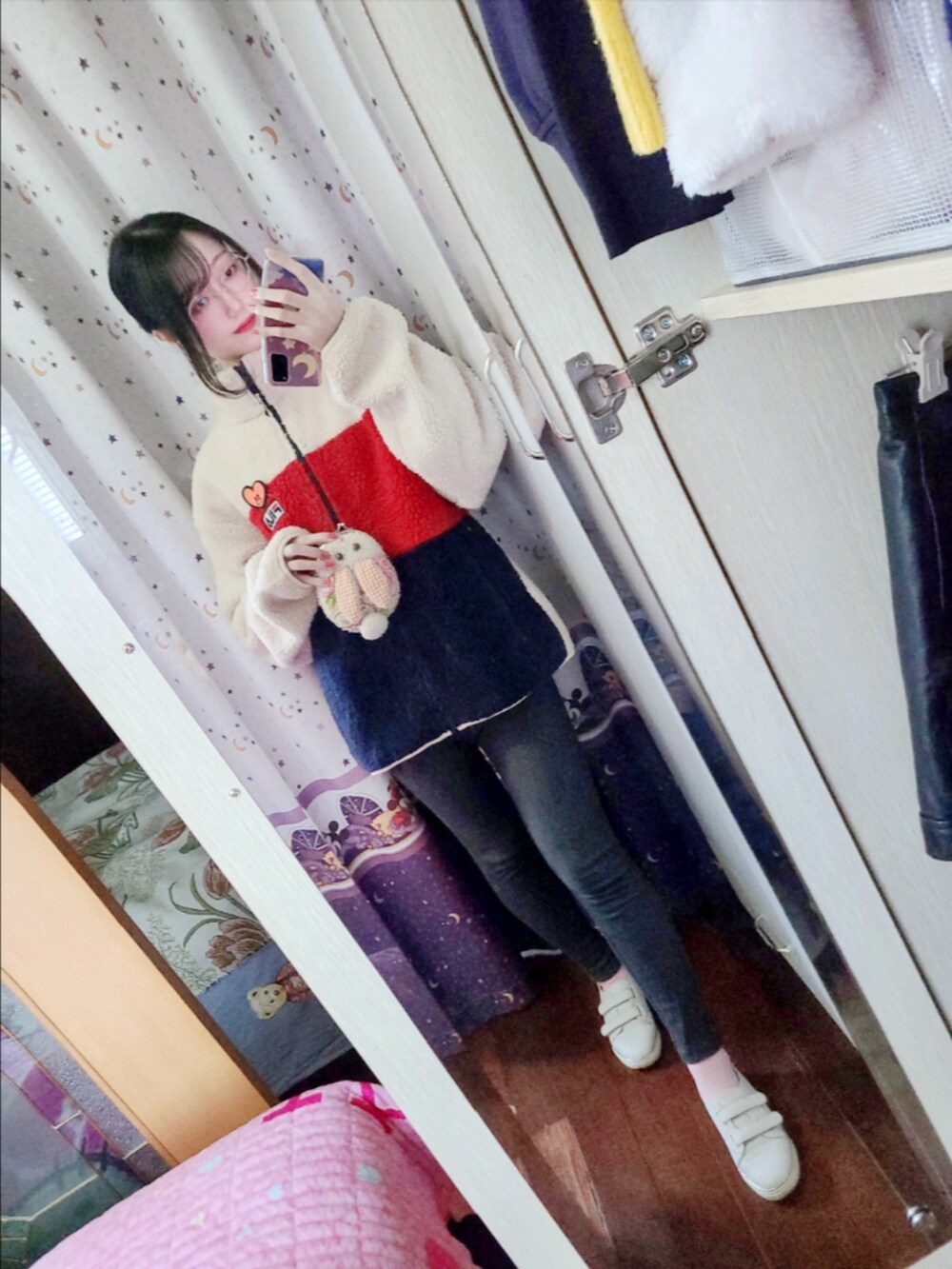 レッド系のスタジャン、その他のデニムパンツ、ピンク系のスニーカーを着用したレディースの冬コーディネートの2枚目の写真