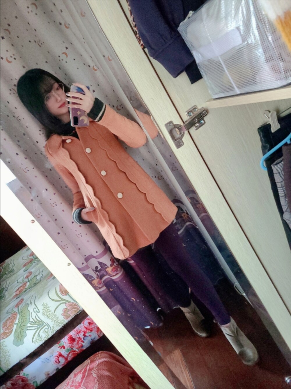 ブラック系のブーティ、オレンジ系のダッフルコート、グリーン系のニット/セーターを着用したレディースの冬コーディネートの2枚目の写真