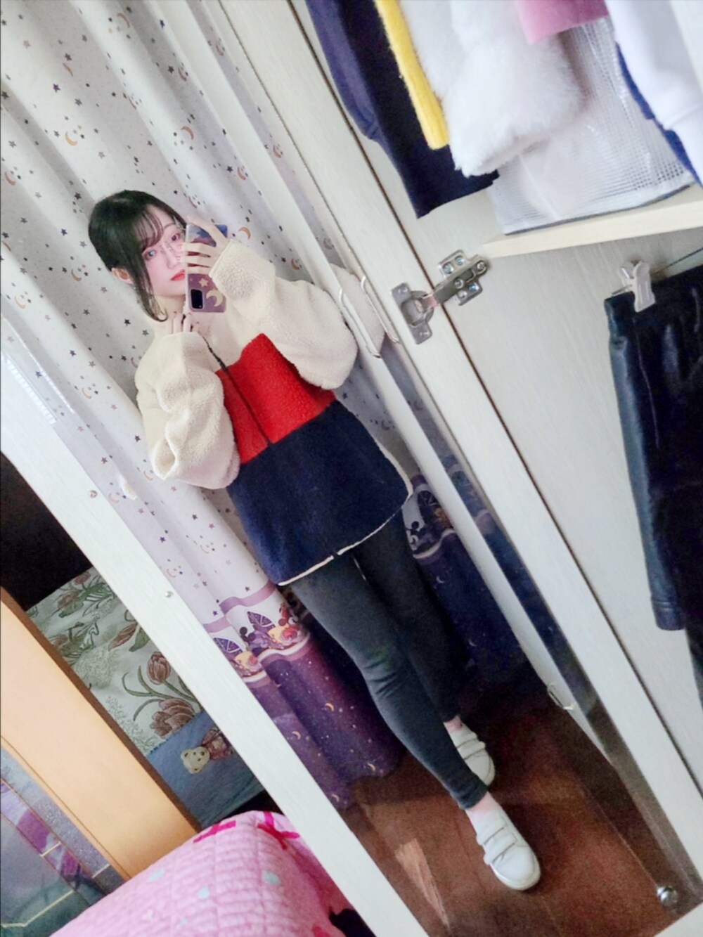 レッド系のスタジャン、その他のデニムパンツ、ピンク系のスニーカーを着用したレディースの冬コーディネートの3枚目の写真