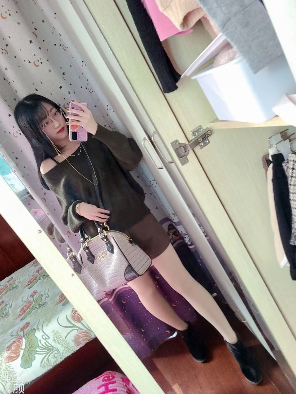 ブラック系のブーティ、パープル系のハンドバッグ、グリーン系のニット/セーターを着用したレディースの春コーディネートの2枚目の写真