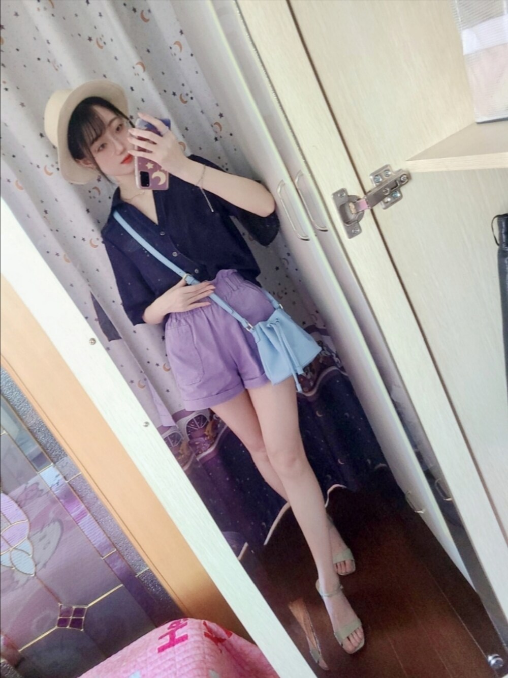 パープル系のカーゴパンツ、ブルー系のドラムバッグ、グリーン系のサンダルを着用したレディースの夏コーディネートの4枚目の写真