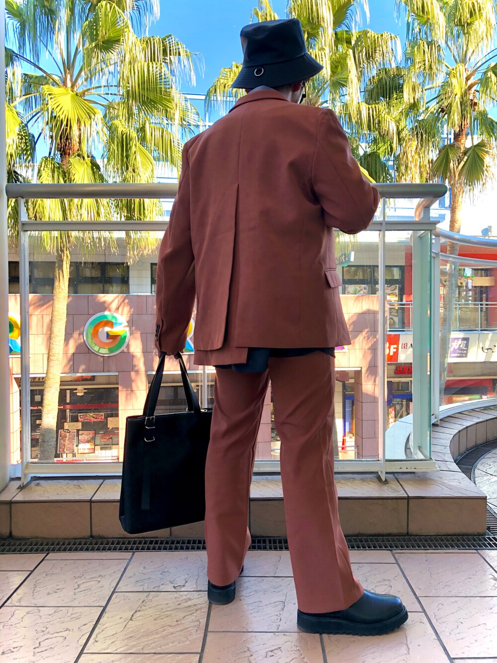 ブラック系のブルゾン、オレンジ系のテーラードジャケット、ブラック系のシャツ/ブラウスを着用したメンズの冬コーディネートの4枚目の写真