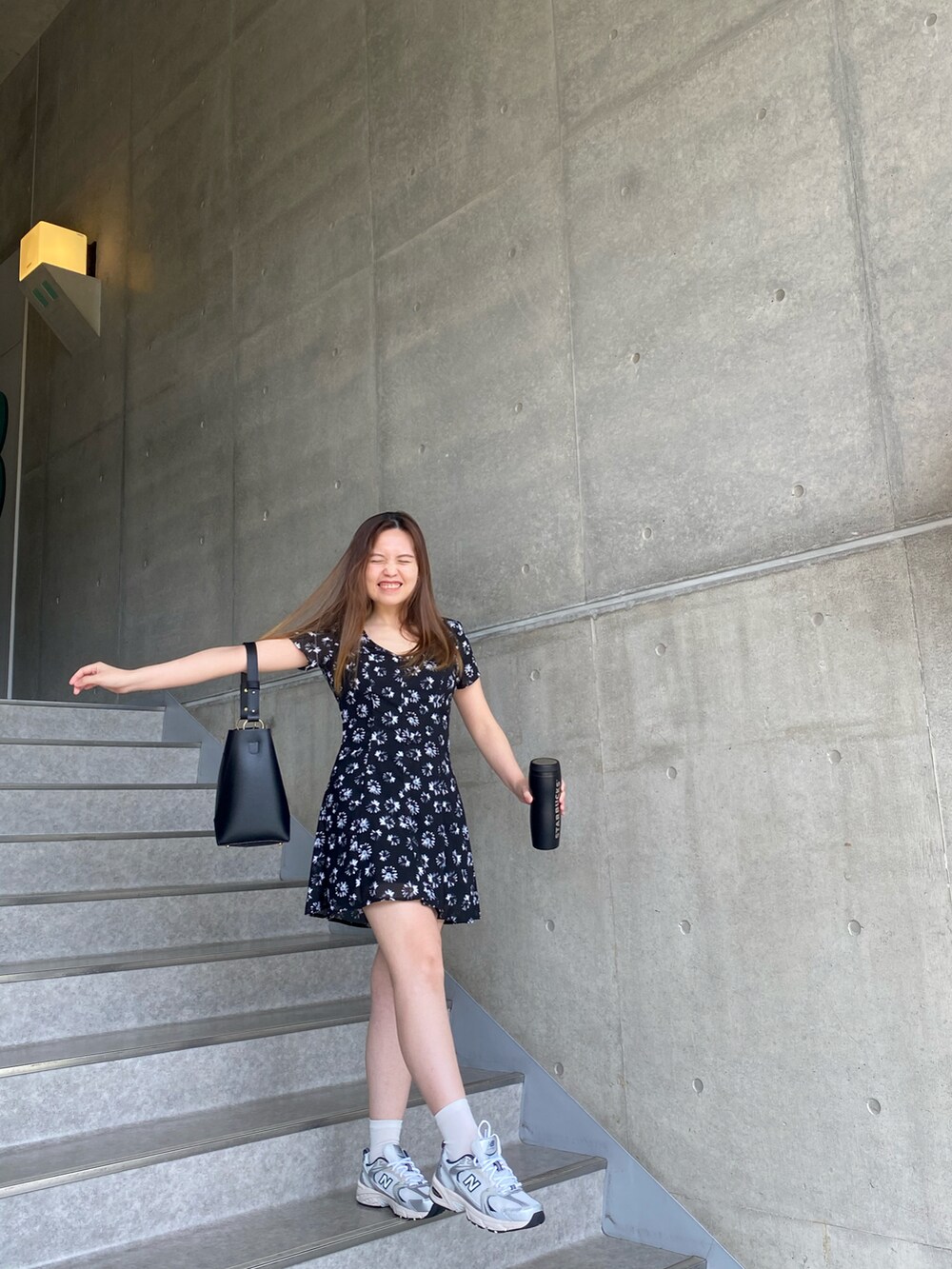 ブラック系のワンピース、グレー系のスニーカーを着用したレディースの夏コーディネートの3枚目の写真