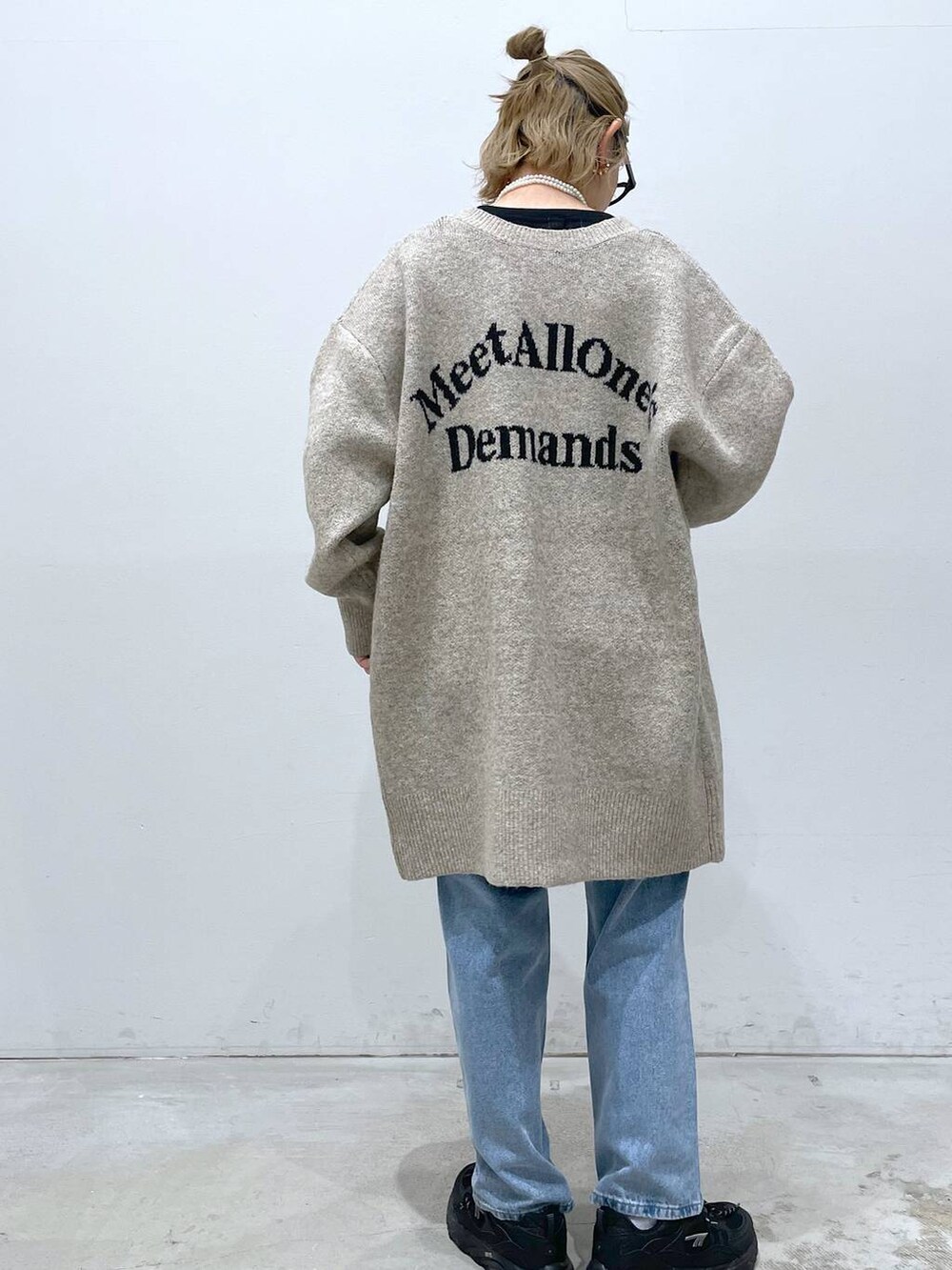 ブルー系のデニムパンツ、ブラック系のTシャツ/カットソー、ブラック系のショルダーバッグを着用したレディースの冬コーディネートの5枚目の写真