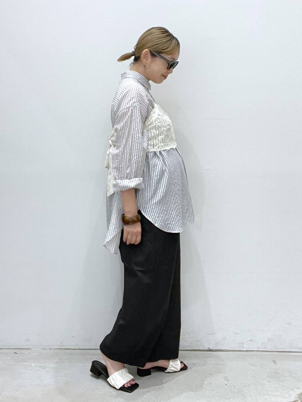 ブラック系のその他パンツ、ホワイト系のサンダル、ホワイト系のキャミソールを着用したレディースの夏コーディネートの2枚目の写真