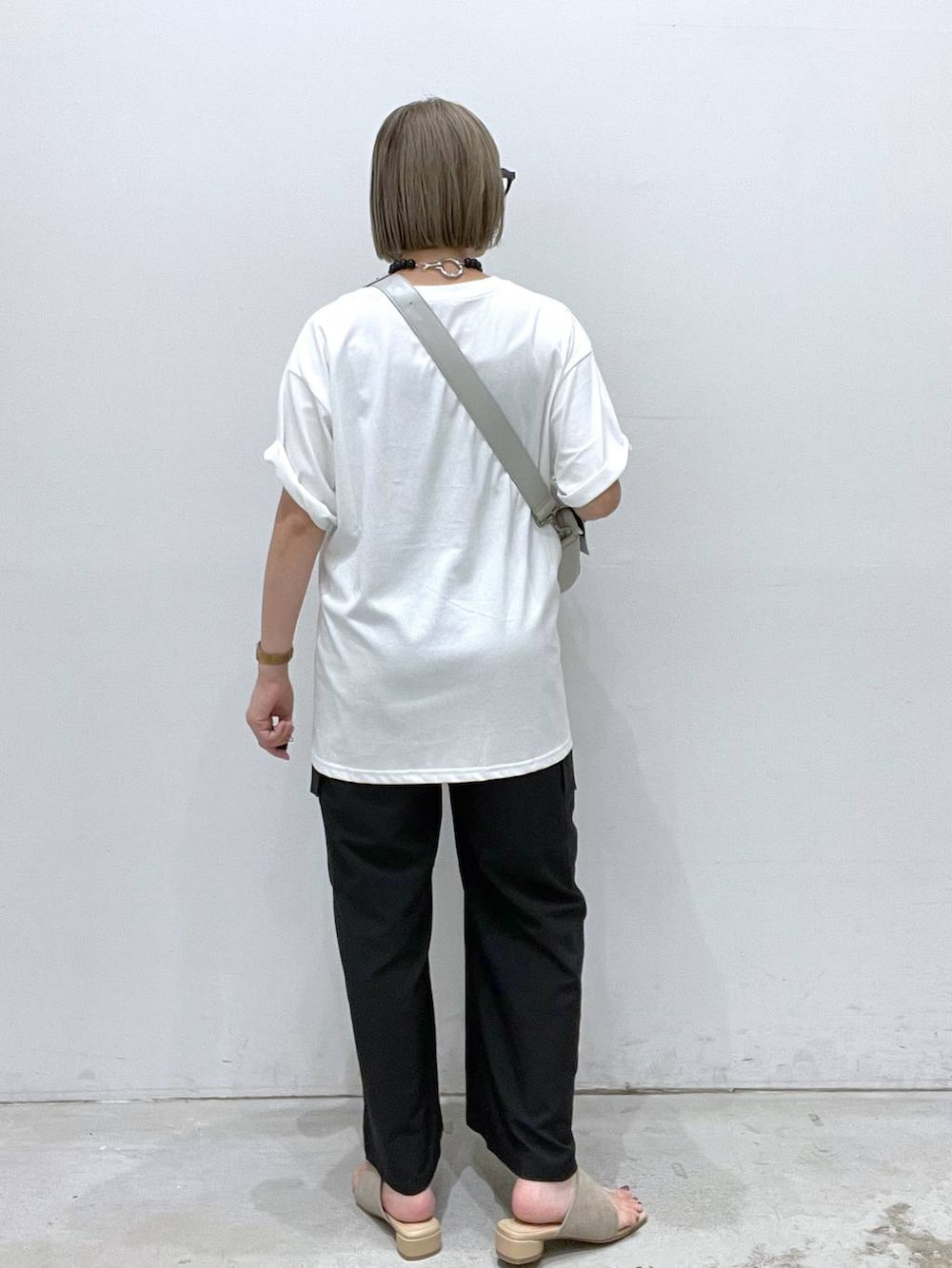 ブラック系のカーゴパンツ、ベージュ系のサンダル、グレー系のショルダーバッグを着用したレディースの夏コーディネートの3枚目の写真