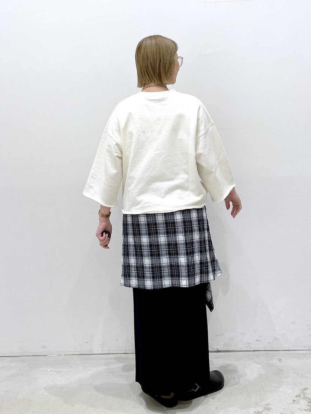 ブラック系のスカート、ブラック系のサンダル、ブラック系のシャツ/ブラウスを着用したレディースの春コーディネートの2枚目の写真