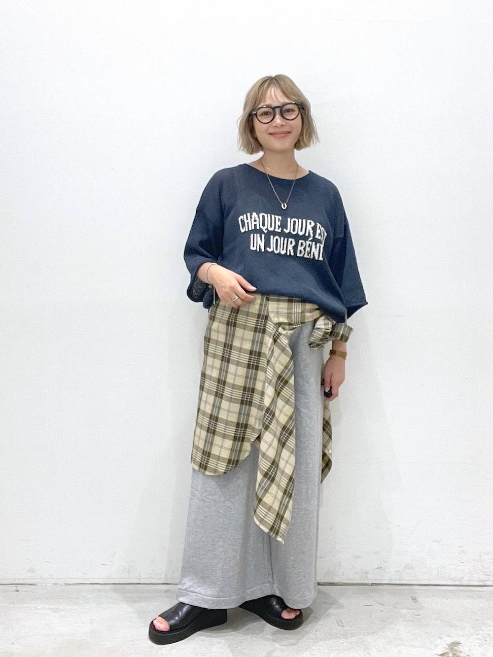 イエロー系のシャツ/ブラウス、グレー系のスウェットパンツ、ブルー系のニット/セーターを着用したレディースの夏コーディネートの2枚目の写真