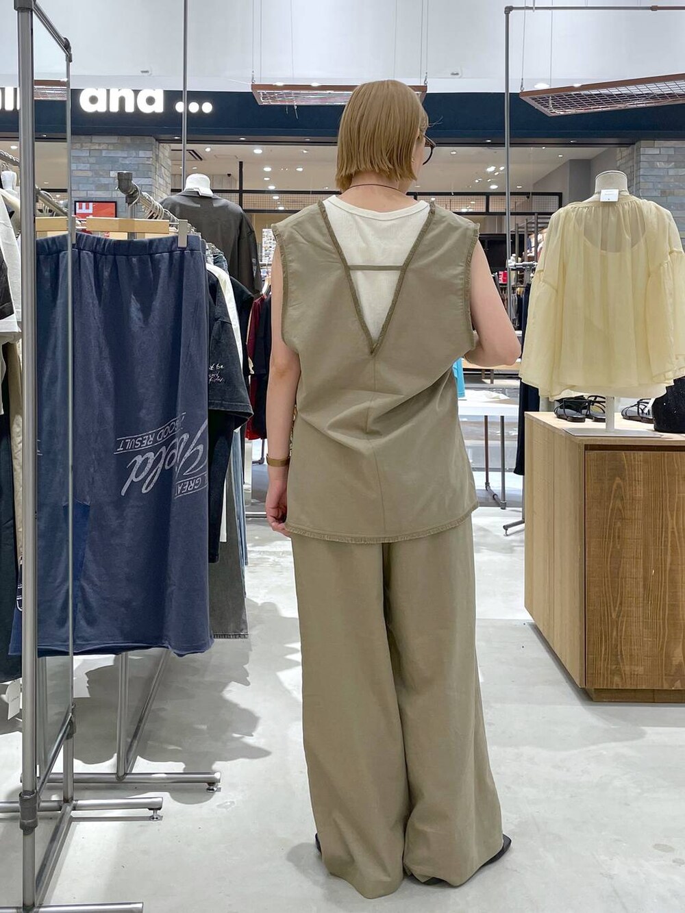 グリーン系のベスト、ホワイト系のタンクトップ、グリーン系のその他パンツを着用したレディースの夏コーディネートの3枚目の写真