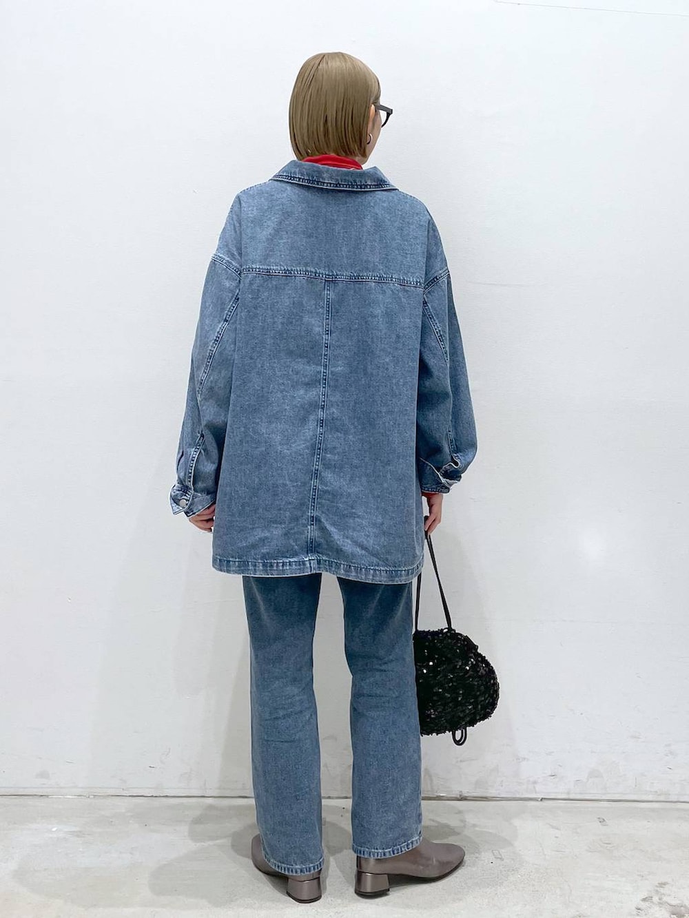 ブルー系のデニムパンツ、その他のブーツ、レッド系のTシャツ/カットソーを着用したレディースの冬コーディネートの4枚目の写真