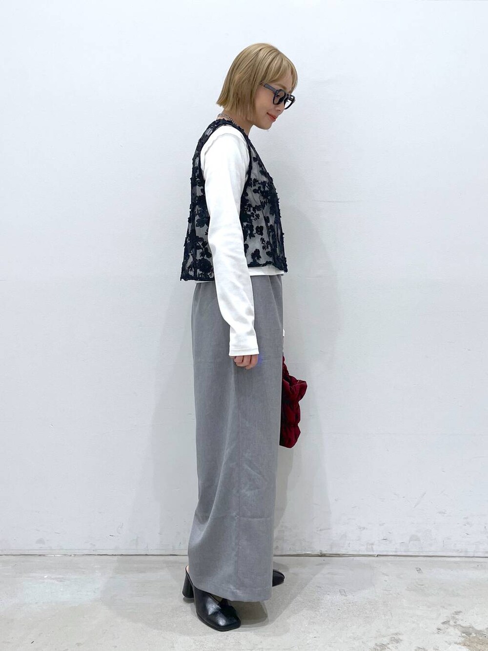 グレー系のその他パンツ、ホワイト系のTシャツ/カットソー、レッド系のショルダーバッグを着用したレディースの冬コーディネートの2枚目の写真