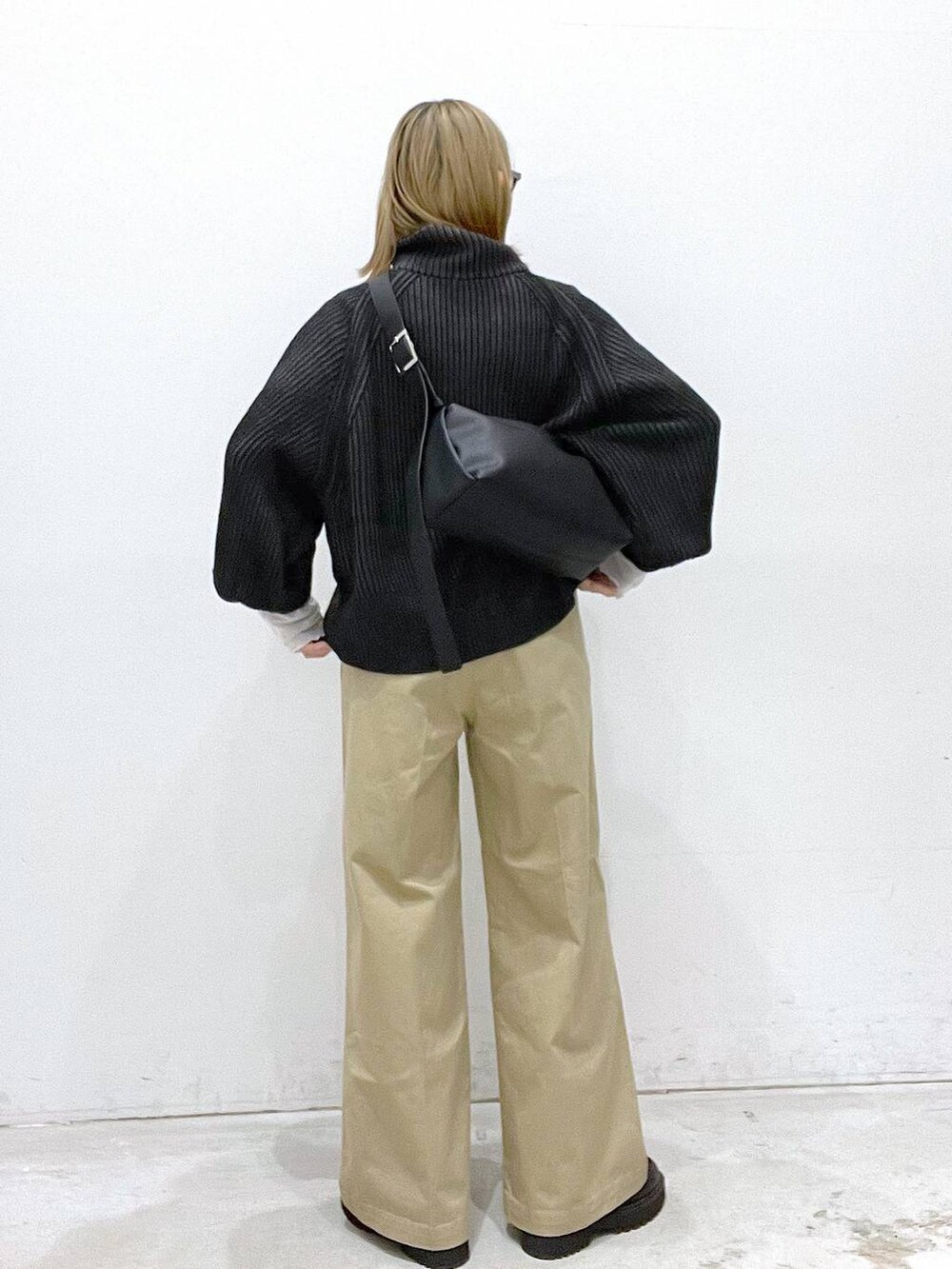 ベージュ系のチノパンツ、ブラック系のブーツ、ブラック系のカーディガン/ボレロを着用したレディースの秋コーディネートの3枚目の写真