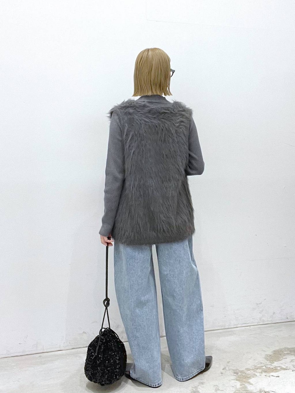 ブラック系のその他シューズ、ブラック系のショルダーバッグ、グレー系のベストを着用したレディースの秋コーディネートの3枚目の写真