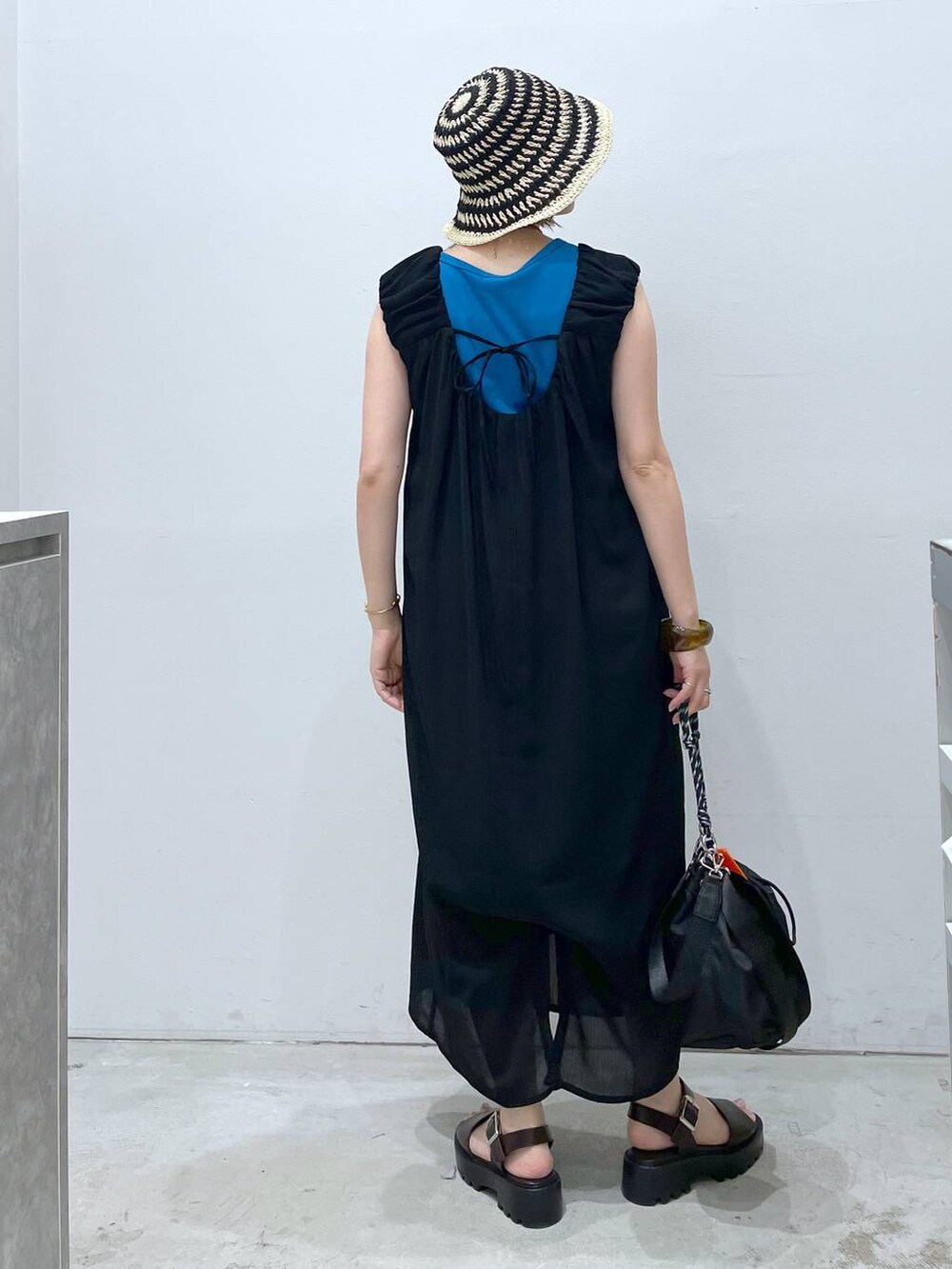 ブルー系のTシャツ/カットソー、ブラウン系のサンダル、ブラック系のショルダーバッグを着用したレディースの夏コーディネートの3枚目の写真