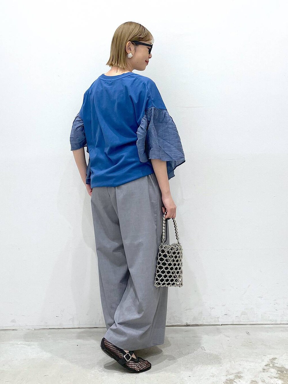 グレー系のその他パンツ、ブラック系のパンプス、ブルー系のTシャツ/カットソーを着用したレディースの春コーディネートの2枚目の写真