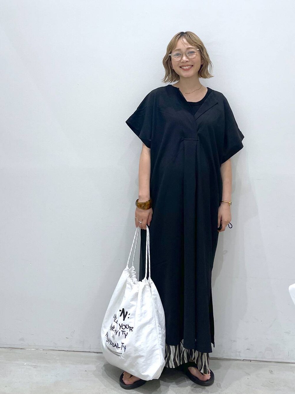 ブラック系のTシャツ/カットソー、ブラック系のワンピース、ホワイト系のショルダーバッグを着用したレディースの夏コーディネートの2枚目の写真