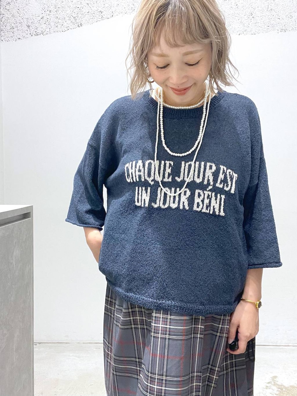 ブルー系のデニムパンツ、グレー系のスカート、ブルー系のニット/セーターを着用したレディースの夏コーディネートの4枚目の写真