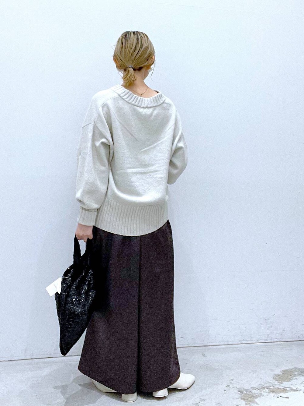 ホワイト系のニット/セーター、ホワイト系のブーツ、グレー系のその他パンツを着用したレディースの秋コーディネートの3枚目の写真