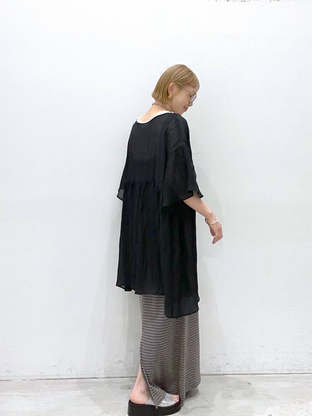 ベージュ系のワンピース、シルバー系のサンダル、ホワイト系のタンクトップを着用したレディースの夏コーディネートの2枚目の写真