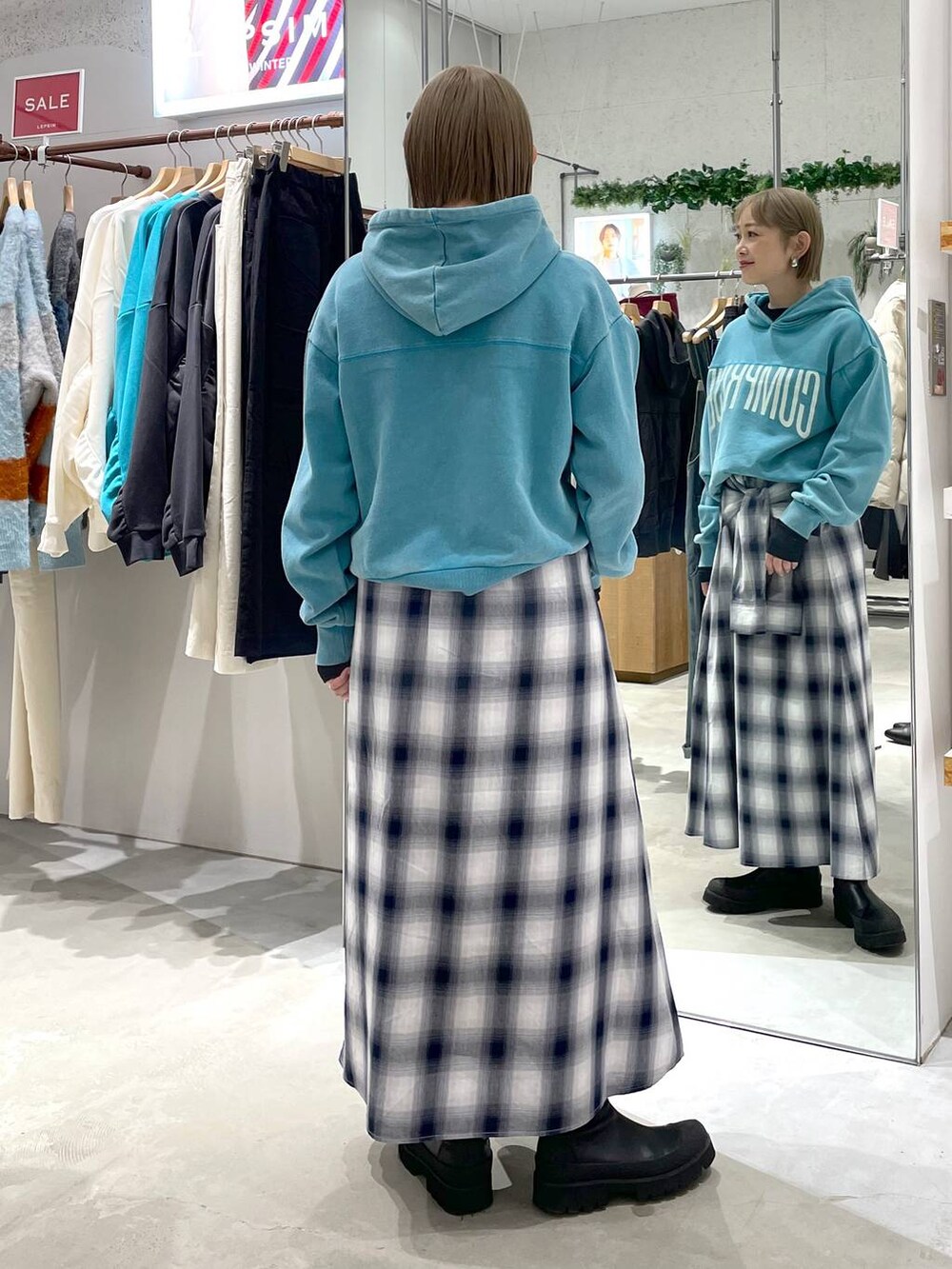 ブラック系のTシャツ/カットソー、ブルー系のスカート、ブルー系のパーカーを着用したレディースの冬コーディネートの3枚目の写真