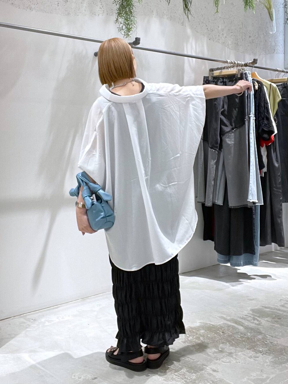 ホワイト系のシャツ/ブラウス、ブラック系のスカート、ブラック系のサンダルを着用したレディースの夏コーディネートの3枚目の写真