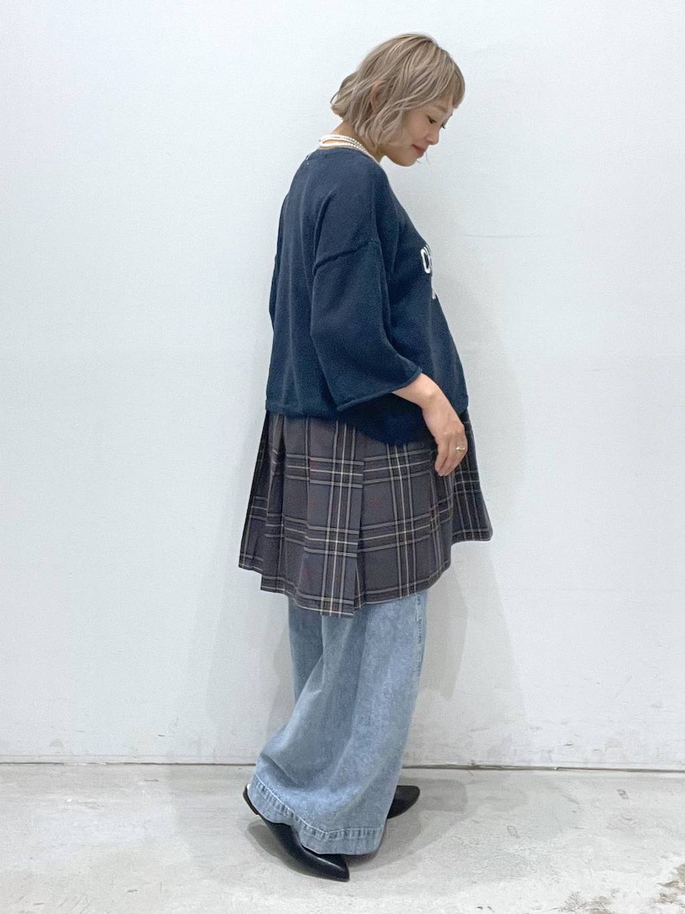 ブルー系のデニムパンツ、グレー系のスカート、ブルー系のニット/セーターを着用したレディースの夏コーディネートの2枚目の写真