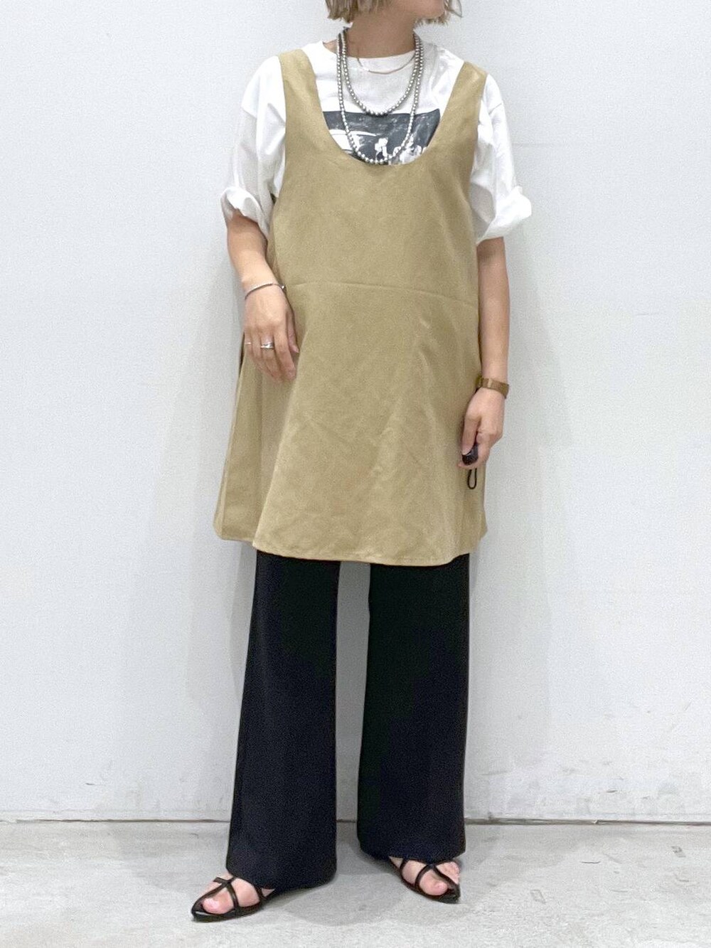 ブラック系のサンダル、ブラック系のその他パンツ、ベージュ系のチュニックを着用したレディースの夏コーディネートの4枚目の写真