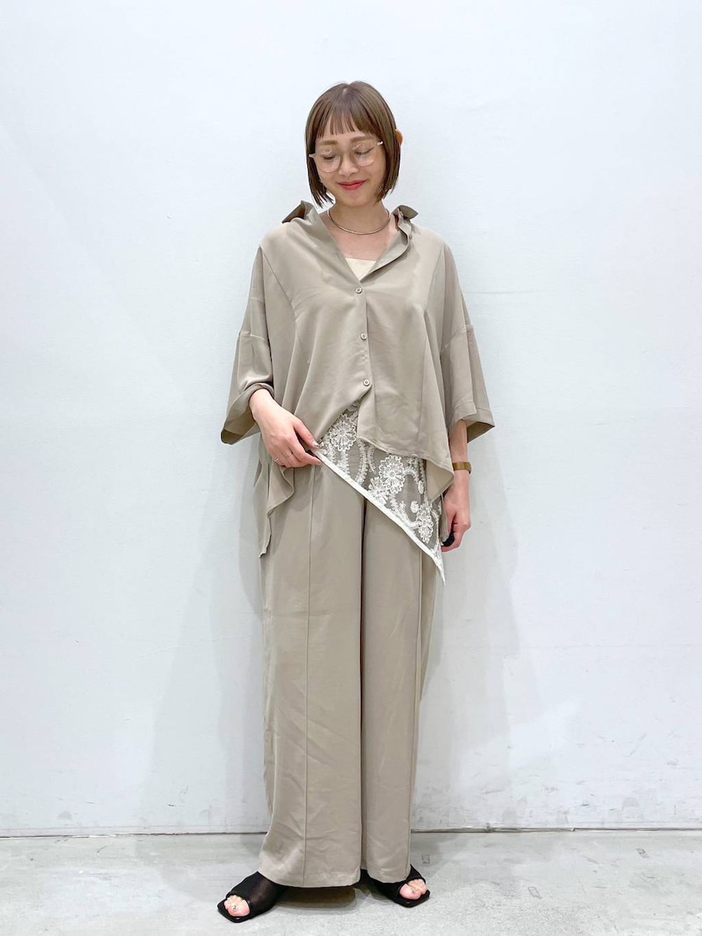ベージュ系のその他パンツ、ホワイト系のタンクトップ、ブラック系のサンダルを着用したレディースの春コーディネートの4枚目の写真