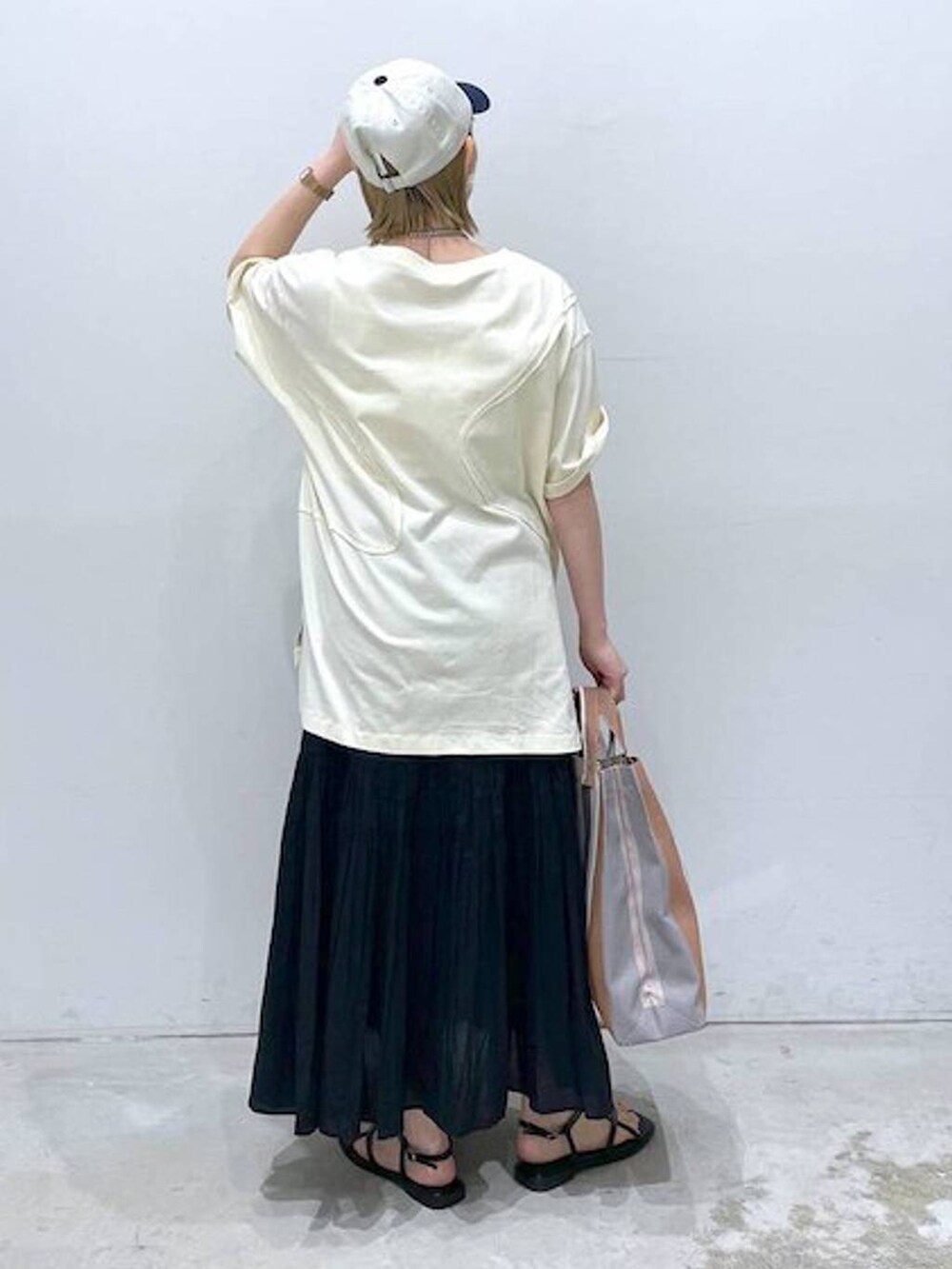 ブラック系のスカート、ブラック系のサンダル、グリーン系のTシャツ/カットソーを着用したレディースの春コーディネートの2枚目の写真