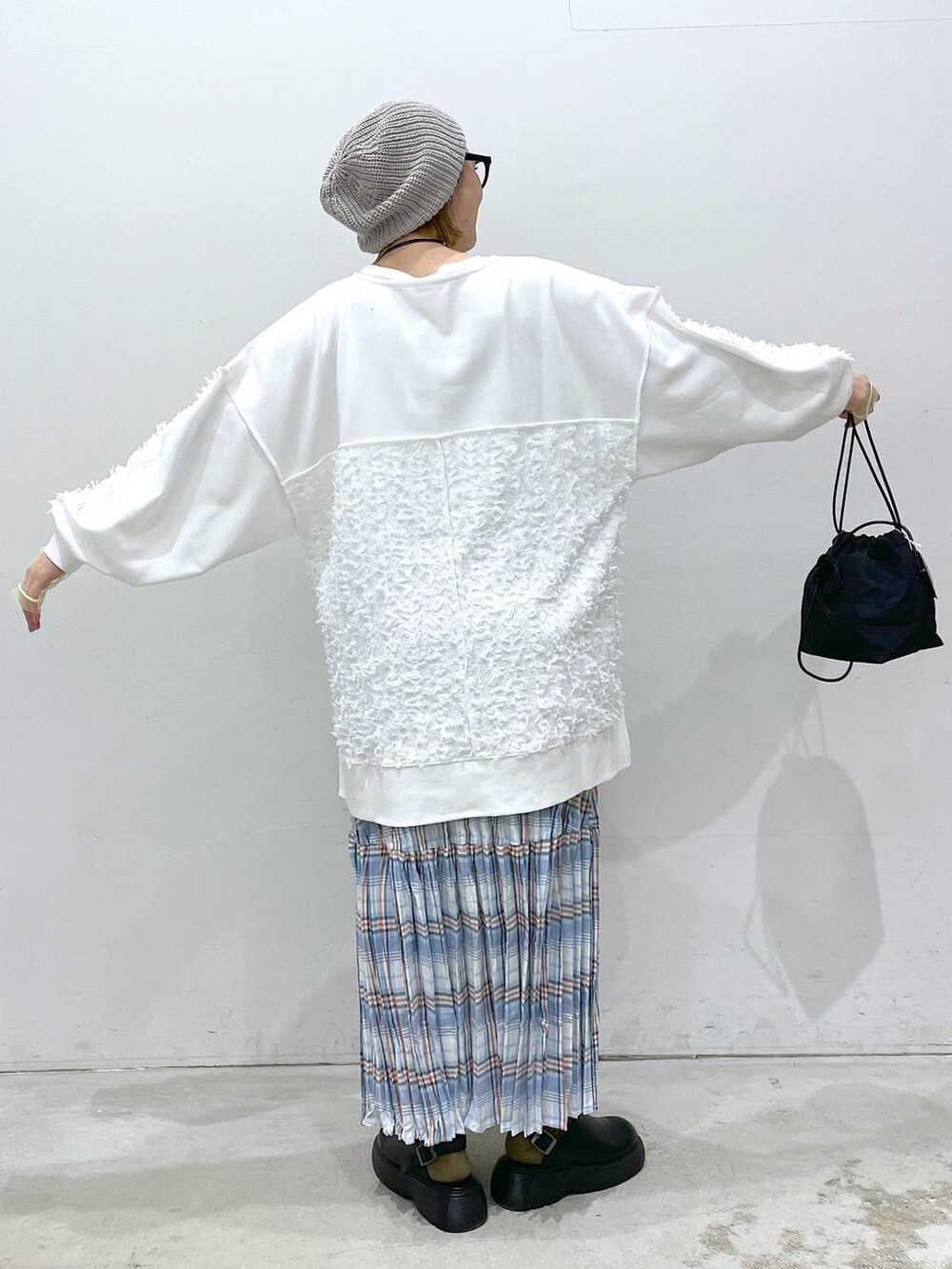 ホワイト系のTシャツ/カットソー、ホワイト系のチュニック、ブラック系のショルダーバッグを着用したレディースの春コーディネートの2枚目の写真