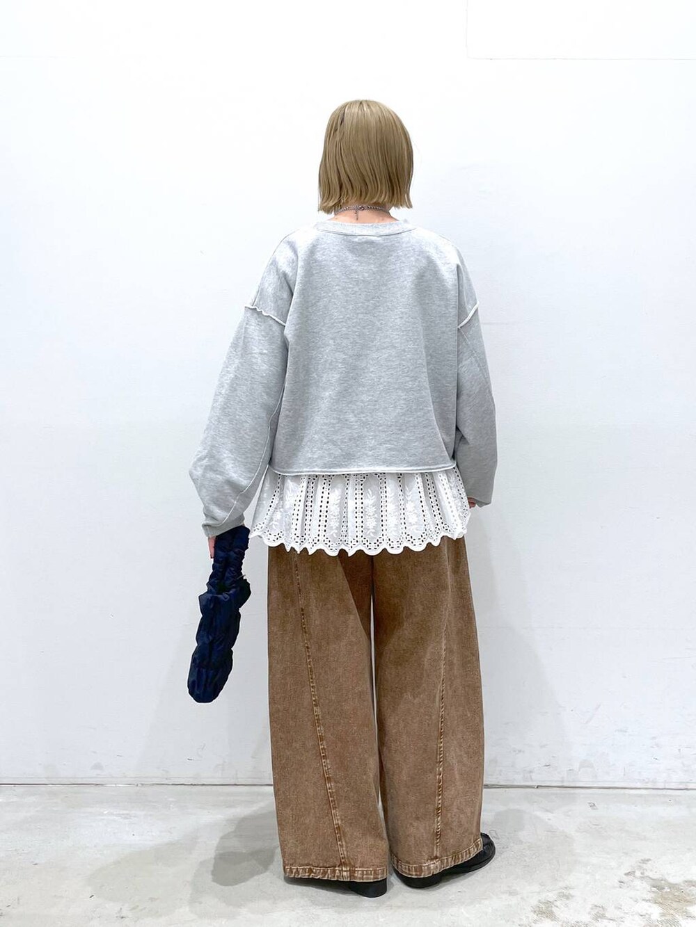 ホワイト系のTシャツ/カットソー、ブルー系のショルダーバッグ、ブラウン系のデニムパンツを着用したレディースの冬コーディネートの4枚目の写真