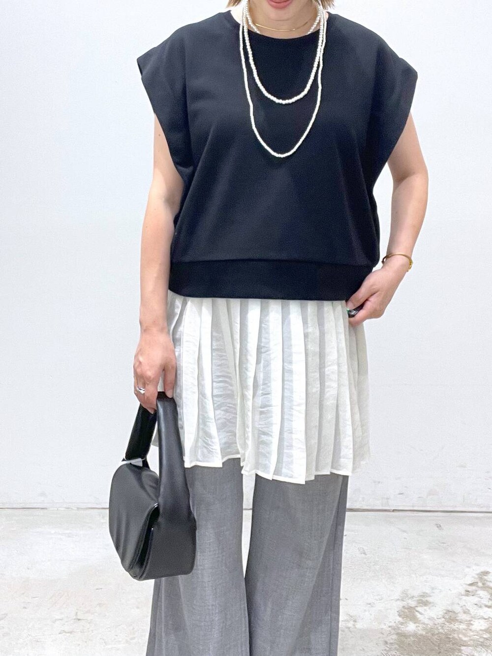 ブラック系のハンドバッグ、グレー系のその他パンツ、シルバー系のサンダルを着用したレディースの夏コーディネートの4枚目の写真