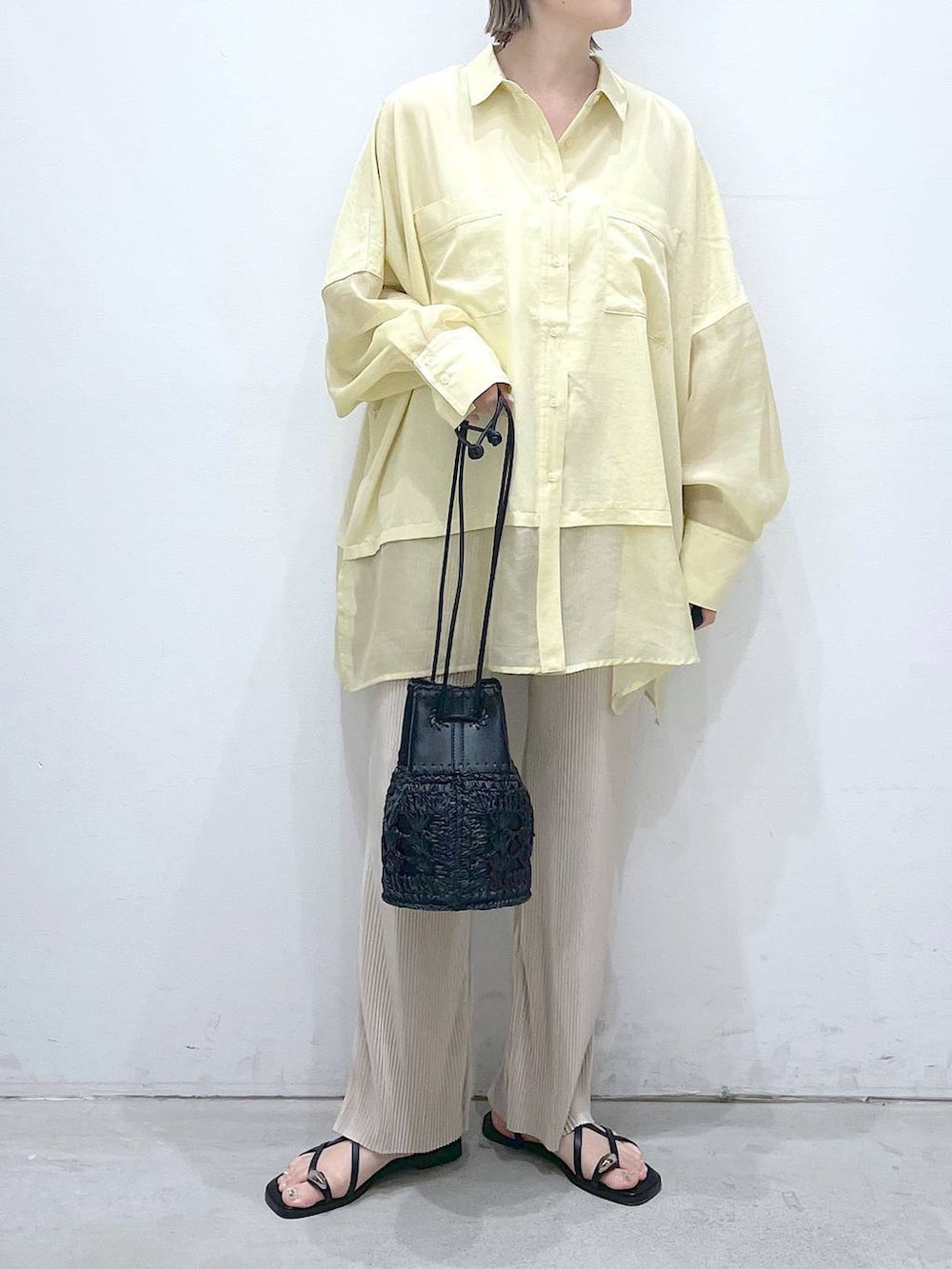 ブラック系のショルダーバッグ、イエロー系のシャツ/ブラウス、ベージュ系のその他パンツを着用したレディースの夏コーディネートの4枚目の写真